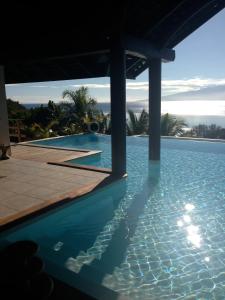 a swimming pool with a view of the ocean at Villa BellaVista in Teavaro