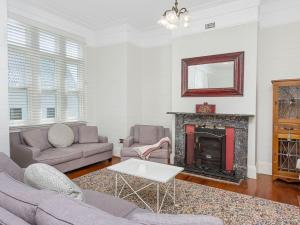 a living room with a couch and a fireplace at Blake House - SPECIAL OFFER STAY 3 PAY for 2 OR 25PERCENT OFF MIDWEEK in Kiama