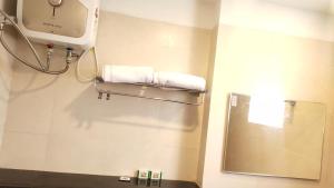 baño con espejo y toallas en la pared en Hotel Rhythm Grand Suite en Tiruchchirāppalli