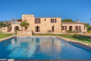 a large swimming pool in front of a house at Es turo de Mallorca in Ses Salines