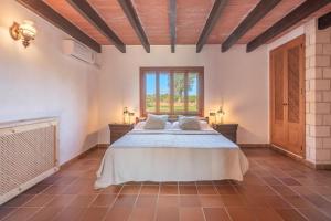 a large bedroom with a bed and a window at Es turo de Mallorca in Ses Salines