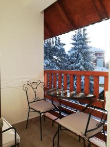 - un balcon avec deux chaises, une table et un arbre de Noël dans l'établissement Frajla, à Zlatibor