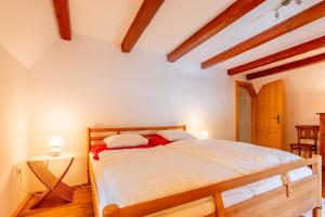 ein Schlafzimmer mit einem Bett in einem Zimmer mit Holzdecken in der Unterkunft Mühle in der Pferdewelt Reichenau in Reichenau