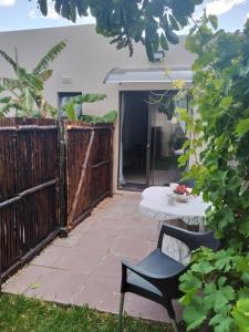a patio with a table and a fence at The Pool Cottage in Fish Hoek