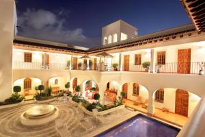 une grande maison avec une piscine dans la cour dans l'établissement Hotel Boutique La Casa Azul, à Cuernavaca