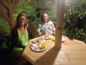 a man and a woman sitting at a table with food at Pondok Diana in Jasri +24 photos