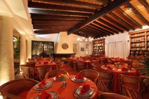 a restaurant with red tables and chairs in a room at Hotel Boutique La Casa Azul in Cuernavaca
