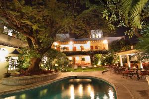 a pool in front of a house at night at Hotel Boutique La Casa Azul in Cuernavaca
