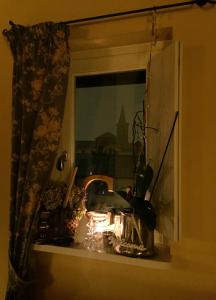 a window with a candle on a window sill at La Casa sui Tetti in Novi Ligure