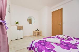 Un dormitorio con una cama morada con toallas. en Apartments BARO en Maranovići