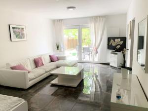 a living room with a white couch and a table at Work & Stay Troisdorf in Troisdorf