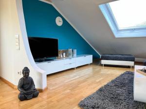 ein Wohnzimmer mit einer Statue, die auf dem Boden sitzt in der Unterkunft Black Forest Appartement - Brandenkopfblick in Zell am Harmersbach