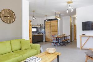 a living room with a green couch and a table at Iron Villas - Nefeli & Oniros in Pangalochori