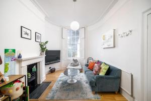 uma sala de estar com um sofá e uma televisão em ALTIDO Modern 4 bed flat with communal courtyard in Angel, East London em Londres
