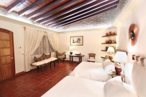 a bedroom with two beds and a table and chairs at Hotel Boutique La Casa Azul in Cuernavaca +19 photos