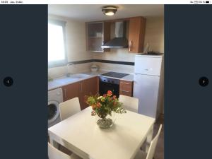 a kitchen with a table with a vase of flowers on it at Appartement Golf PANORAMICA in Sant Jordi