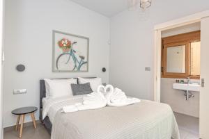 a white bedroom with a bed with towels on it at Seaview Apartment SUNRISE Near To Falassarna Beach in Kolymvari