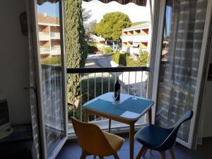 une chambre avec une table, des chaises et une fenêtre dans l'établissement Bandol nature et loisirs: Parking/ Piscine, à Bandol