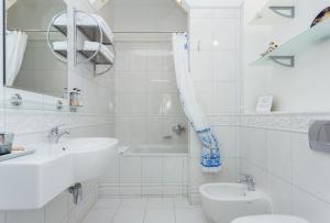 a white bathroom with a sink and a tub and a toilet at Casa Leto in Saint Petersburg +37 photos