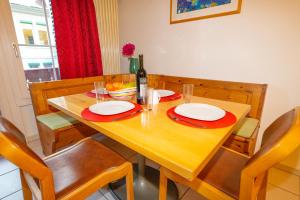 een houten tafel met borden en een fles wijn bij Waldeg 4 Historic House - Holiday Apartment in Interlaken
