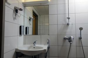uma casa de banho com um lavatório e um espelho em Forenom Aparthotel Kemi em Kemi