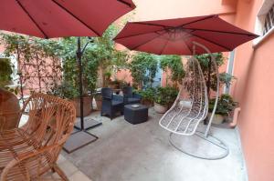 un patio con 2 sillas y una sombrilla roja en B&B Corte Dei Figuli, en San Pietro in Lama