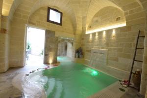 San Pietro in LamaにあるB&B Corte Dei Figuliの大きなバスタブ付きの客室内の大きなプールが備わります。