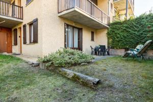 a house with a yard with chairs and a table at Le Chanchore - appartement 2 chambres avec jardin proche Embrun in Saint-Sauveur