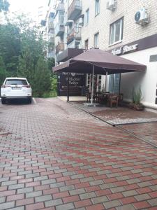 un coche aparcado frente a un edificio con sombrilla en Hotel Voyage, en Járkov