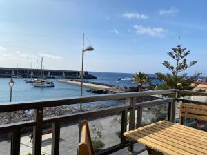 a balcony with a bench and a view of the water at Los Zifios in La Restinga