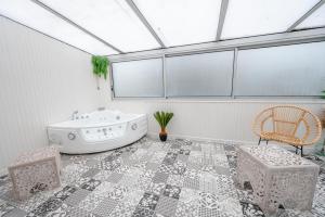 a bathroom with a bath tub and two chairs at NG SuiteHome - Lanester Lorient - Balnéo - Netflix - Wifi in Lanester