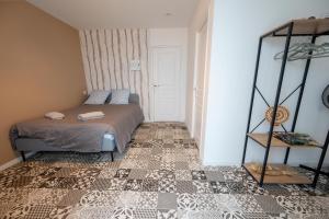 a bedroom with a bed and a mirror at NG SuiteHome - Lanester Lorient - Balnéo - Netflix - Wifi in Lanester