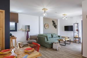 a living room with a green couch and a table at Iron Villas - Nefeli & Oniros in Pangalochori +51 photos