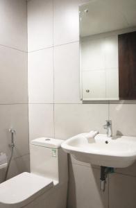 Baño blanco con lavabo y aseo en StayG Eastern Green by GranDhika - Bekasi, en Padurenan