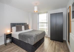 a bedroom with a bed and a dresser at Dream Apartments Belfast in Belfast