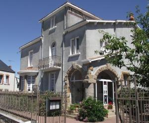 a gray house with a fence in front of it at Logement de La Sittelle in Aizenay