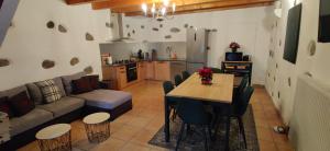 a kitchen and living room with a table and a couch at Gîte Vallée Verte in Burdignin