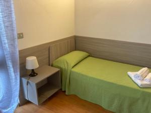 a small room with two beds and a lamp at Albergo Ristorante Lis Aganis in Frisanco