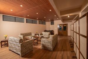 a waiting room with couches and a table and chairs at Hotel Shambhala in Gangtok