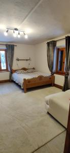 BurdigninGîte Vallée Verte的有两张床和两扇窗户的卧室