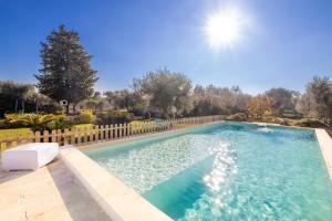 una piscina in un cortile con recinzione in legno di Villa Acqua Azzurra a Ceglie Messapica