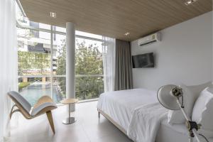 Un dormitorio con una cama y una ventana grande. en Veranda Residence Pattaya Pool Villa, en Na Jomtien 22 fotos más