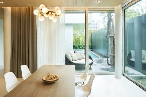 Un comedor con una mesa y sillas blancas. en Veranda Residence Pattaya Pool Villa, en Na Jomtien