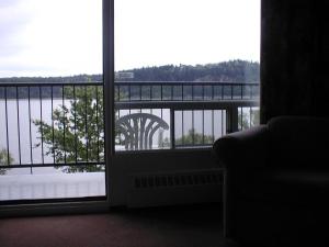 a room with a view of the water from a window at Motel Panoramique in Saguenay