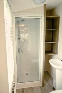a glass shower in a bathroom with a sink at Plot 188D Lakeside Cabin, Wyldecrest, Millom in Millom
