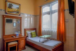 um pequeno quarto com uma cama e uma janela em Urbanview Hotel Anugrah Kendal by RedDoorz em Bandengan
