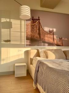 a bedroom with a painting of a bridge on the wall at Logvinenko apartment in Bishkek