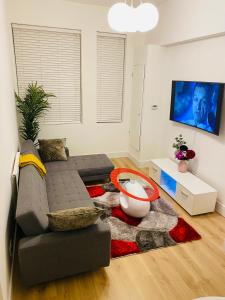 a living room with a couch and a table at Spacious 2 Bedroom Apartment in Woolwich Arsenal in Woolwich