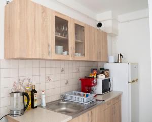 a kitchen with a sink and a white refrigerator at KeramikArt-Wohnung in Pécs