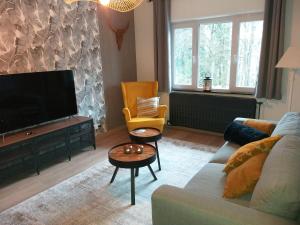 uma sala de estar com um sofá e uma televisão de ecrã plano em La Maison de Sidonie em Jalhay